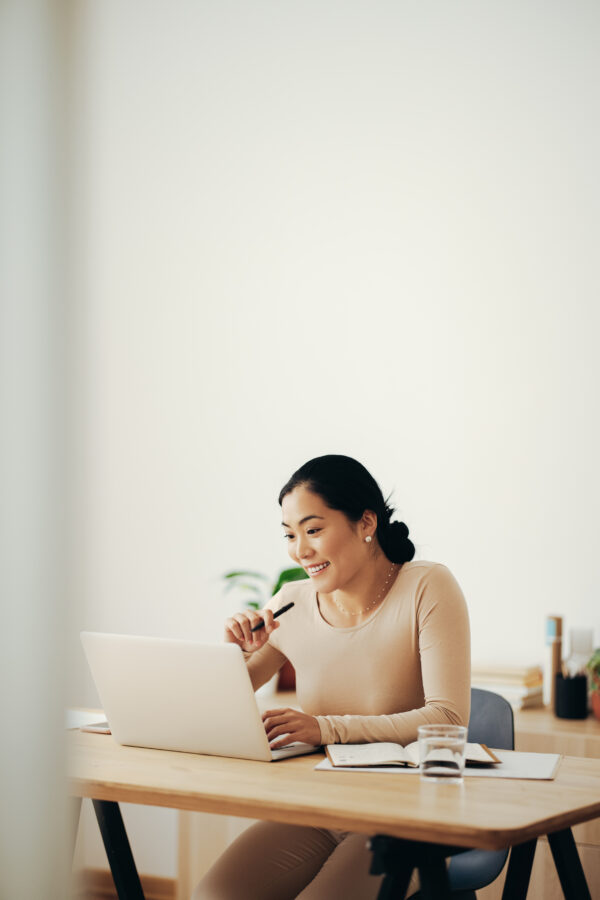 Happy Business Woman Working from Home on Laptop Computer
